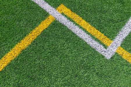Green artificial grass turf soccer football field background with white and yellow line boundary. Top viewの写真素材