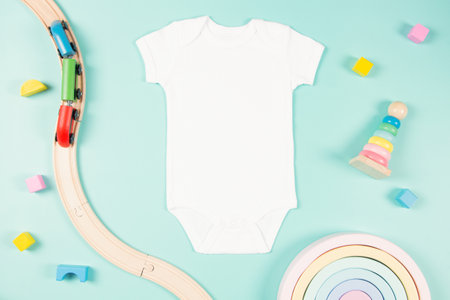 White cotton baby short sleeve bodysuit and natural wooden eco-friendly educational toys on pastel background.の写真素材