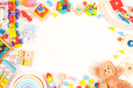 Baby kids toy background. Teddy bear, plush, wooden educational, musical, sensory, sorting and stacking toys, train, colorful building blocks on white background. Montessori toys. Top view, flat layの写真素材