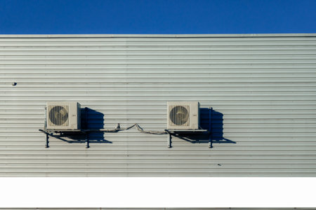 Two old air conditioner hangs on corrugated sheet metal wall of warehouse, storage, store. Industrial look. Outdoorの写真素材