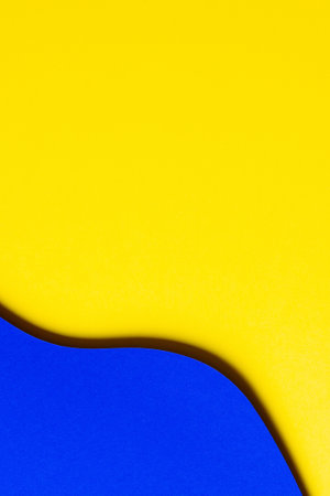 Abstract colored paper texture background. Paper cut style composition with layers of geometric shapes and lines in bold yellow and blue colors. Top viewの写真素材