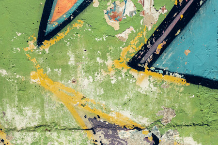 Detail of colorful graffiti wall. Old weathered colorful graffiti painted peeled plaster wall with falling off flakes of paintの写真素材