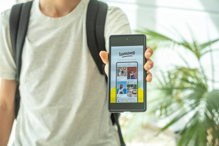 Benidorm, Spain - April 06, 2023: Teenage boy show phone with open content sharing platform with...