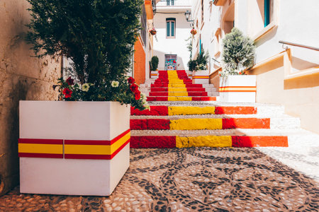 View of Calpe old town on sunny day. Stairs adorned with colors of Spanish flag, Calpe, Alicante province, Valencian Community, Spainの写真素材