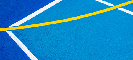 Sport field court background. Blue rubberized and granulated ground surface with white, yellow lines...