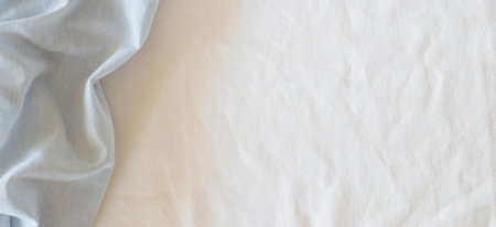 Abstract crumpled linen fabric texture background. Natural light blue hue dyed linen and white color...