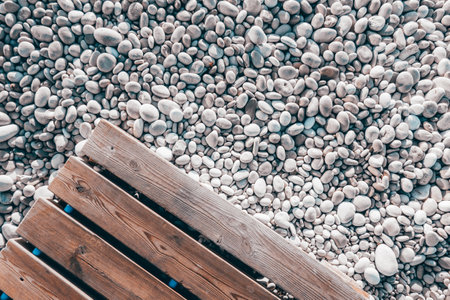 Wooden beach boardwalk with white pebbles background. Top viewの写真素材