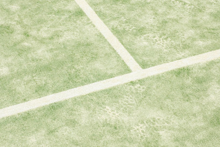 Sport field court background. Outdoor paddle tennis court filled with sand. Light green ground...
