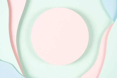 Blank pink round geometric shape podium platform on paper cut abstract geometric shape pastel pink, blue and green background. Top view mock up for product displayの写真素材