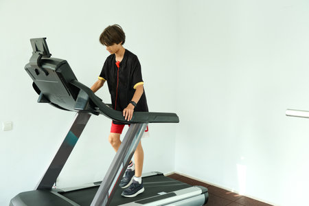 Teenage boy running on treadmill in gym. Sport, cardio, strength training, fitness concept