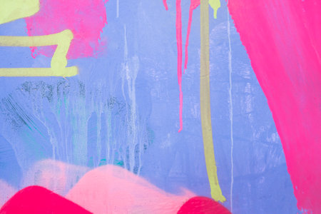 Messy paint strokes and smudges on an old painted wall. Purple, pink, yellow color drips, flows, streaks of paint and paint spraysの写真素材
