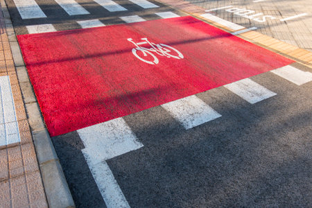 Crossroads in the city. Bike path next to pedestrian crossing on street road. Bicycle lane sign marked on asphaltの写真素材