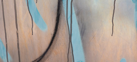 Messy paint strokes and smudges on an old painted wall background. Abstract wall surface with part of graffiti. Colorful drips, flows, streaks of paint and paint spraysの写真素材
