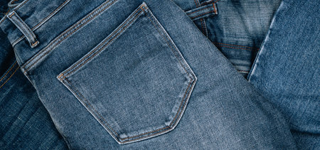 Denim background. Pile of blue jeans. Variety of casual trousers and clothes. Top view to stack of jeans denimの写真素材