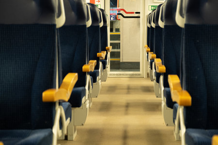 Modern passenger train for long and short distance travel in Europe. Empty interior of train carriage with empty blue seats for comfortable passenger transportationの写真素材