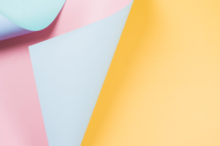 Abstract wave of yellow, pastel pink and light blue paper. Creative geometric curved solid color paper with light and shadows. Abstract geometry background with copy spaceの写真素材