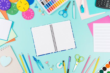 Back to school background. Colored pencils, books, notebooks, pens, watercolor paint, scissors, math fractions, calculator on pastel green background. Top view, flat lay, copy space for textの写真素材