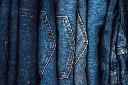 Denim background. Pile of blue jeans. Vertical storage of clothing. Top viewの写真素材