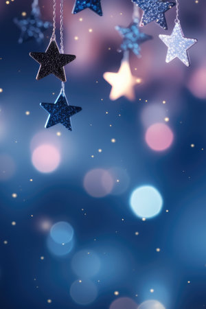 Abstract Christmas background with copy space for product or text. Small pink silver glitter stars on navy blue background with bokehの素材