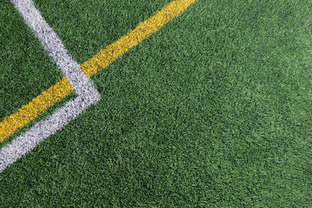 Green artificial grass turf soccer football field background with white and yellow line boundary. Top viewの写真素材