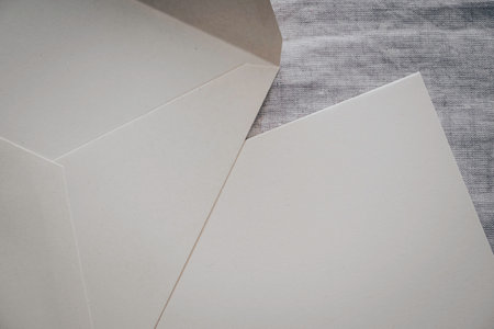 Close up to open envelope and blank card on natural off-white linen background. Top viewの写真素材