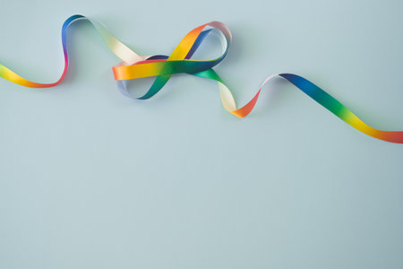 Autism acceptance month, Autism awareness day concept. Rainbow colors ribbons in shape of infinity loop on blue background. Infinity is symbol of autism, adhd, neurodiversityの写真素材