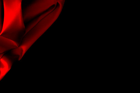 Red silk fabric drapery on flat black silk background with copy space for text or productの写真素材