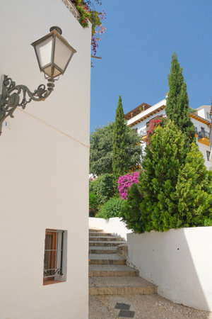 Narrow cozy street with stairs and whitewashed houses in Altea old town. Small picturesque Altea town near Mediterranean sea, Alicante province, Spainの写真素材