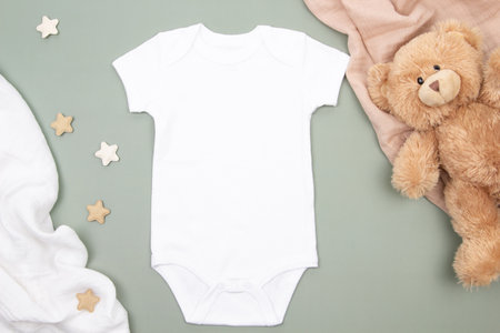 White blank baby bodysuit onesie mock up and kid toy teddy bear on white and brown cotton fabric background. Mockup. Top viewの写真素材