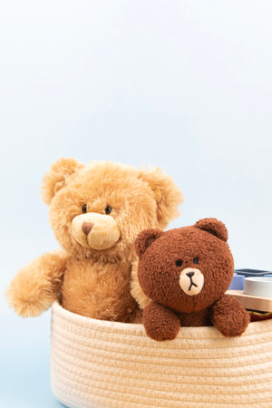 Toy teddy bears and kid toys in white fabric storage box standing on neutral backgroundの写真素材