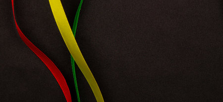 Black History Month, Juneteenth background. Red, yellow, green satin ribbons gently swirling on...