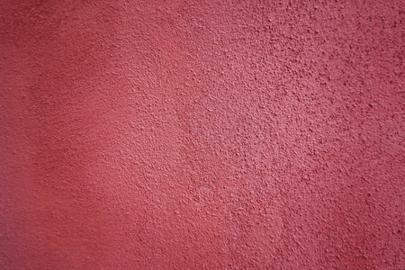 Textured grunge red wall with a rough surface outdoors