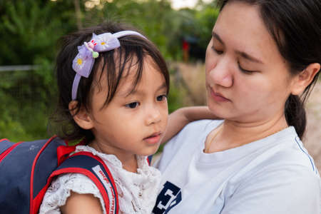 Parents hold the girl to persuade her to go to school.