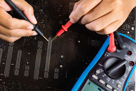 Check the computer motherboard's circuit pattern with a multimeter.の写真素材