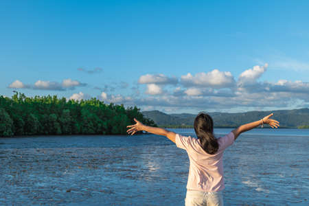 The woman stood with her arms outstretched as she felt free to go out to sea on vacation.