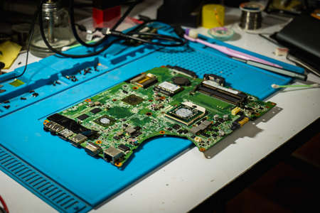 The unpacked motherboard was placed on the desk waiting for a technician to check and repair it.