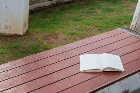 The notebook was placed on a wooden table in the garden.の写真素材