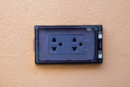 An outlet with a safety cover was installed side-to-side into the egg-colored wall.の写真素材