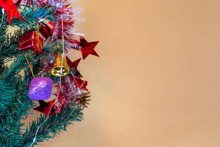 Decorate your Christmas tree with Christmas decorations including led lights, balls, pine cones, bells, and small gift boxes.の写真素材