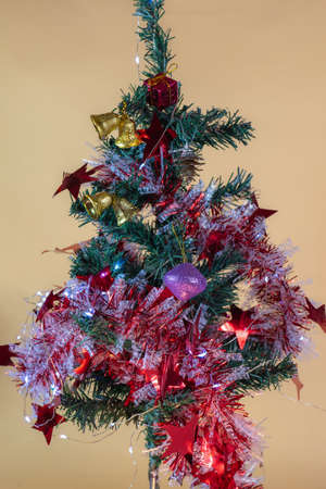 Decorate your Christmas tree with Christmas decorations including led lights, balls, pine cones, bells, and small gift boxes.の写真素材
