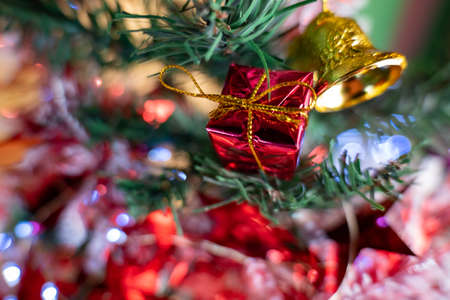 Decorate your Christmas tree with Christmas decorations including led lights, balls, pine cones, bells, and small gift boxes.の写真素材
