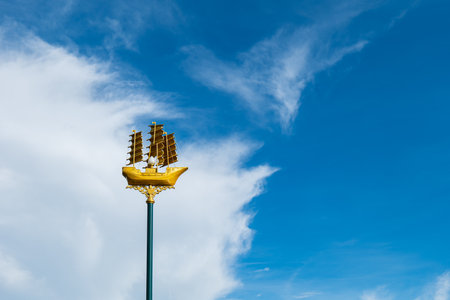 Light poles illuminate the park walkway along the canal. It was designed in the shape of a golden boat to match the canal with boats passing by.の写真素材