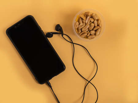 Peeled peanuts and garlic slices are fried in oil and blotted out for a snack during fun activities.