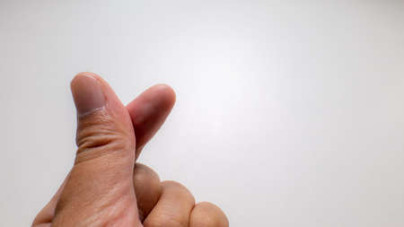 The crossed thumb and index finger symbolizes a small heart called mini heart, believed to be from South Korea.の写真素材