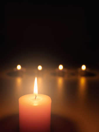 Light a candle in the dark, the flame warms and the light creates bokeh. Light and shadow create atmosphere. Things such as romantic, mysterious, interesting, and also make you feel faith.の写真素材