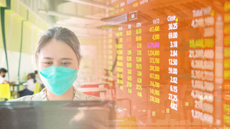 Businesswoman, Asian woman come out and sit in public Look at stock prices on data tables, charts, rising and falling prices, candle charts to make a profitable purchase decision.の写真素材