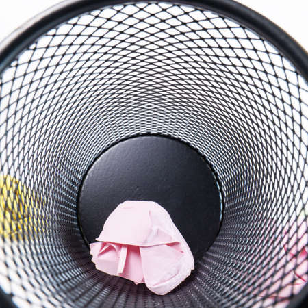 Inside a small black basket made of round iron fell down. It is used to put the trash, documents that are not working and are overflowing to the outside.の写真素材