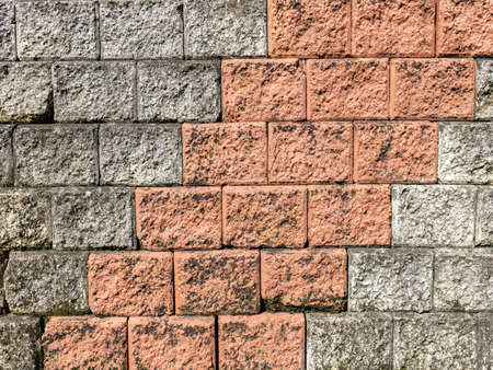 The wall surface is made of bricks in two colors. Taken outside of a strong land where there are shadows.の写真素材