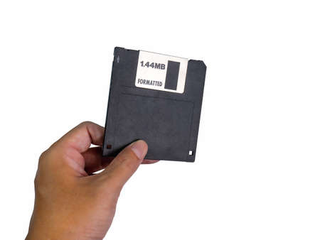 Hand holding a Floppy A disc, insert the reader. to read and write data It's technology old that have been used for a long time has a rectangular shape, white background, has Clipping pathの写真素材