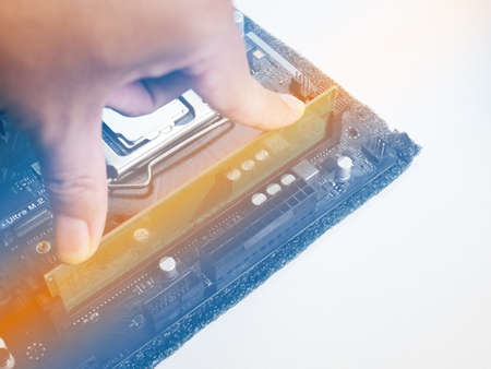 Use your finger to press the RAM into the RAM slot on the motherboard. It's a new motherboard. Put the orange light on the RAM slot. There is a CPU slot next to it. There is a capacitor.の写真素材